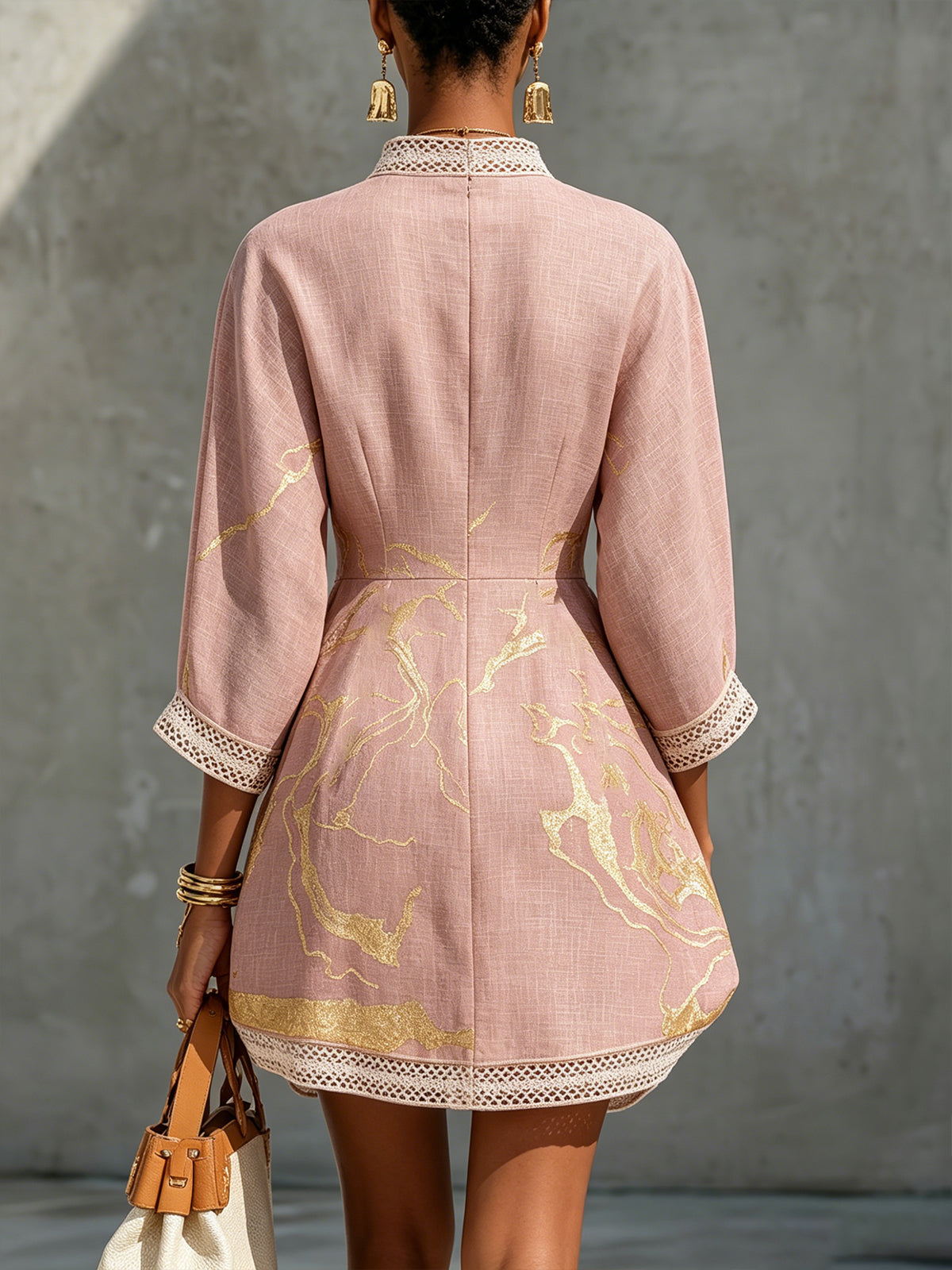Back view of pink midi dress with gold pattern, V-back opening, lace cuffs and hem