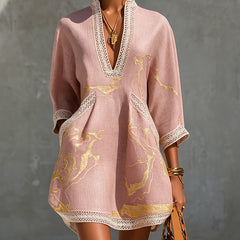 Pink midi dress with V-neck, gold motif print, and white lace trim, quarter sleeves