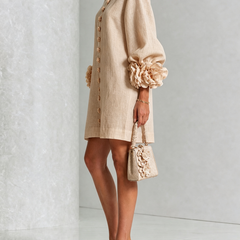 Beige button-front midi dress with long sleeves and rosette cuffs, side view