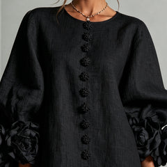 Black midi dress close-up with floral button placket and puff sleeves