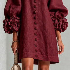 Burgundy linen midi dress close-up with rosette sleeve cuffs and embroidered button placket