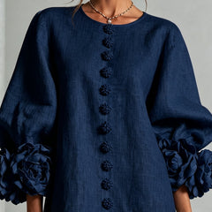 Navy embroidered midi dress close-up showing button trim down the front and puff sleeves
