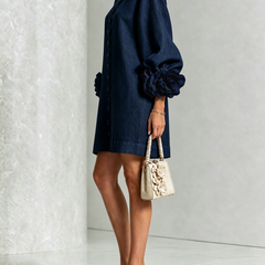 Dark navy button-front midi dress, long sleeves with rosette cuffs, side view