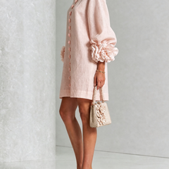 Light pink button-front midi dress with rosette sleeve detail, side view