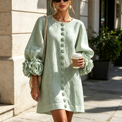 Sage green button-front mini dress with embroidered front placket and ruffled rose sleeve cuffs.
