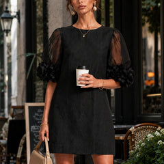 Black midi dress with sheer puff sleeves and rosette cuffs, crew neckline.