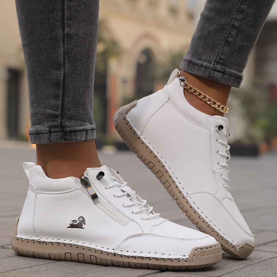 White trainers with side zip and lace-up closure, worn with jeans