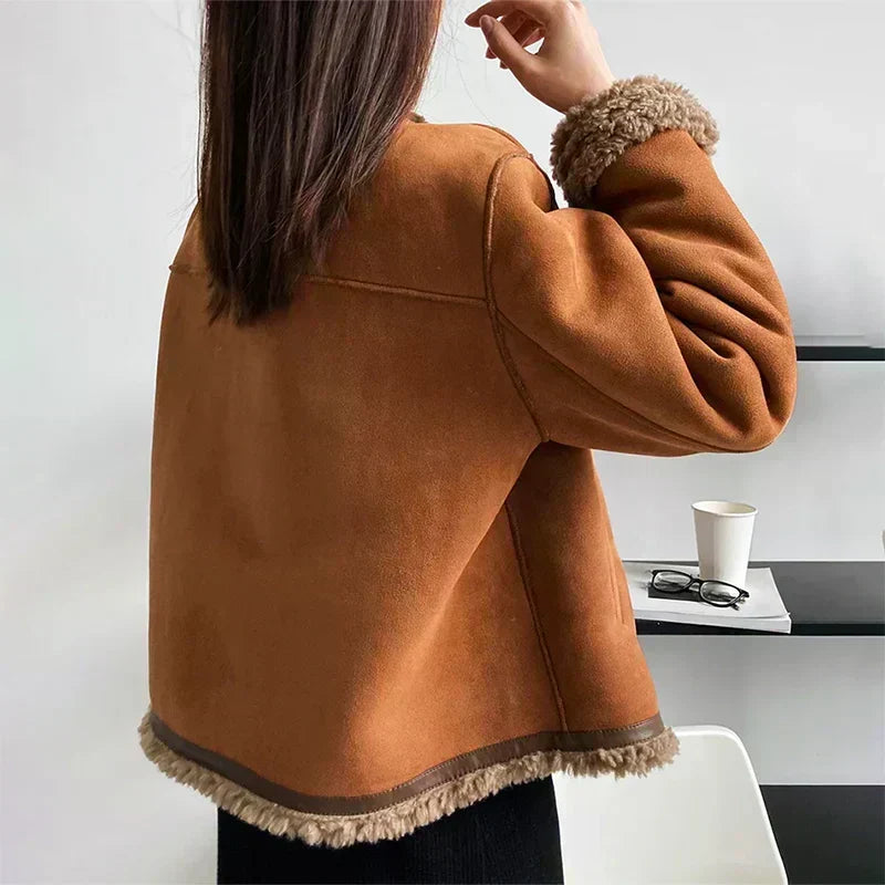 Brown suede jacket with sherpa-trimmed hem and pockets, rounded collar detail.