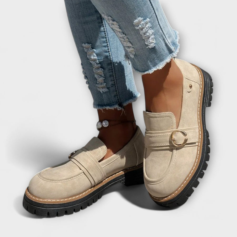Beige suede loafers with D-ring strap and rugged lug sole, worn with jeans