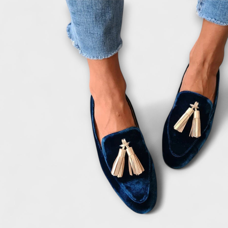 Navy velvet loafers with tassel detail, worn