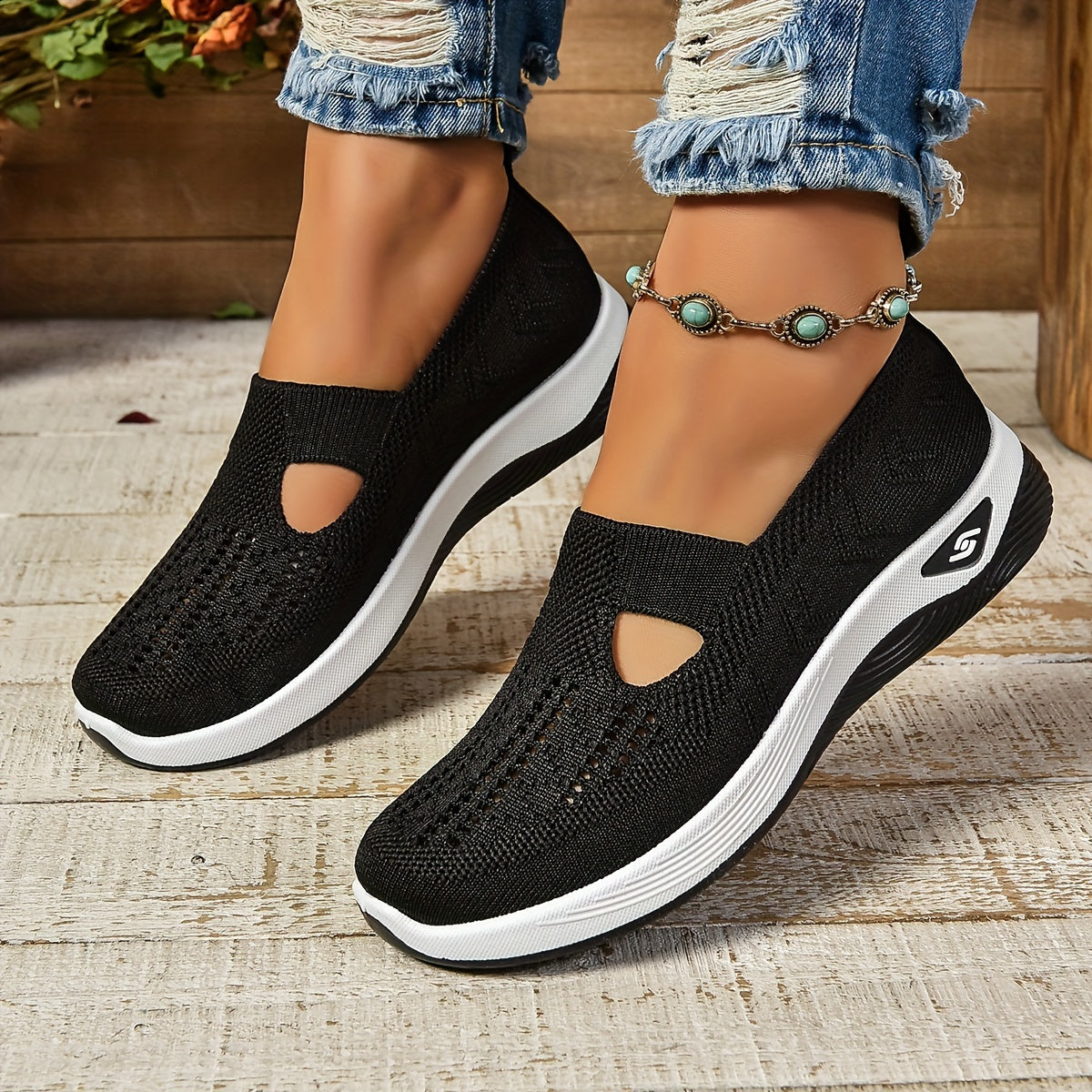 Black knit slip-on shoes with side cutouts and white sole