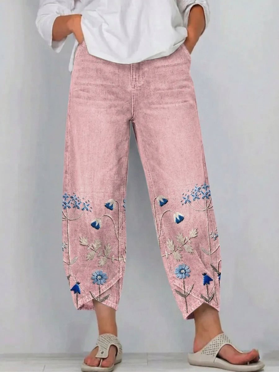 Pink linen pants with embroidered floral panels on the lower legs