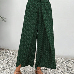 Green wide-leg trousers with shirred waistband and micro pattern, wide flowing drape.