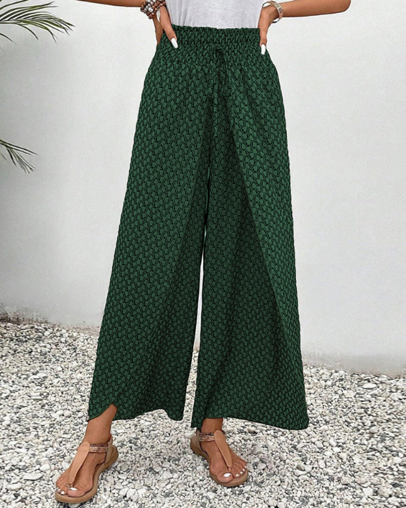 Green wide-leg trousers with shirred waistband and micro pattern, wide flowing drape.