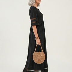 Black midi dress, side view, gathered waist, sheer stripe sleeves, and sheer hem panel