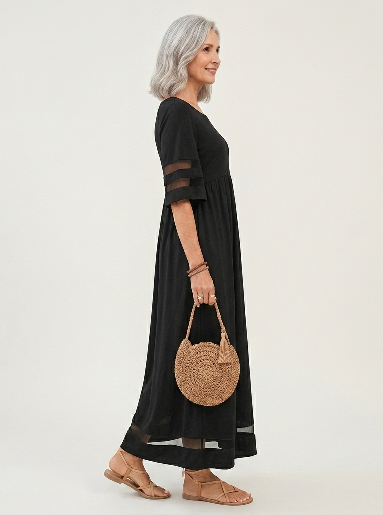 Black midi dress side view with sheer arm cutouts and dark hem trim