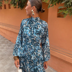 Blue floral midi dress with high neck, long sleeves, and tiered ruffle hem