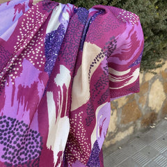Yllana one-shoulder dress close-up, draped sleeve with purple and white abstract print