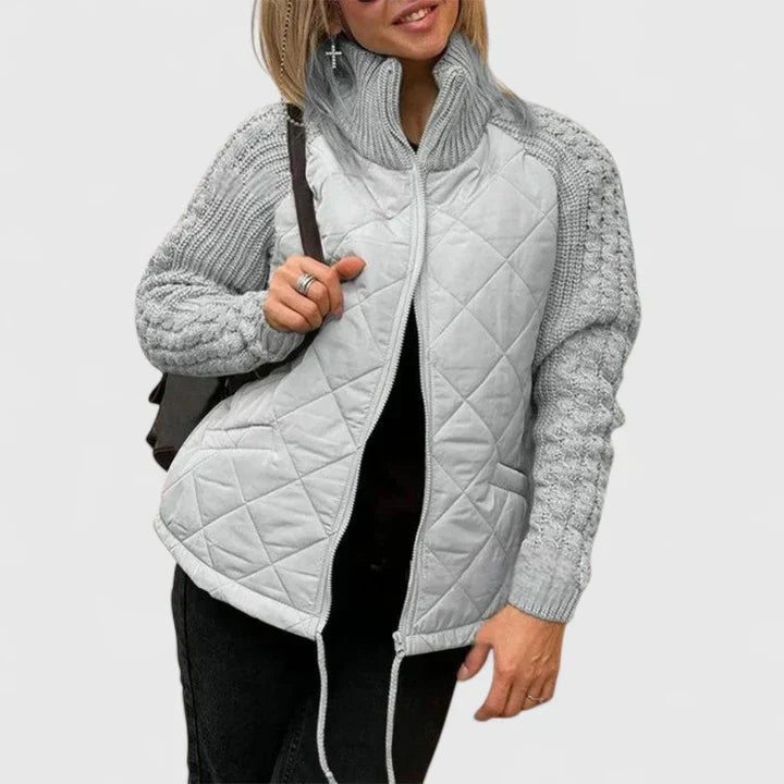 Quilted zip-up jacket with gray knit sleeves and stand collar