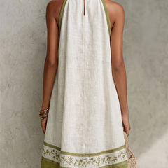 Back view of white halter midi dress with keyhole neck and green floral hem
